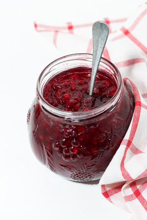 jar with sweet cowberry jam on white table, vertical closeupの写真素材