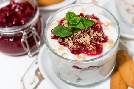 sweet dessert in a glass with biscuits, cream and jam, top view closeupの写真素材