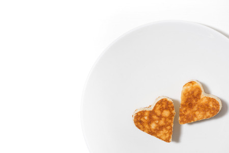 plate of pancakes in the shape of heart on white background, top viewの写真素材
