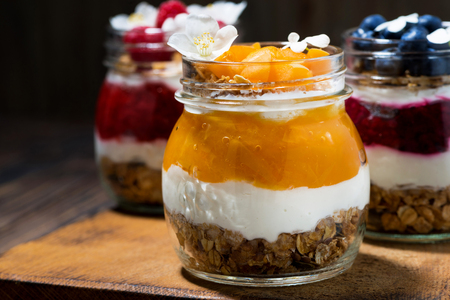 breakfasts in jars with muesli, berry puree and cream, closeup horizontalの写真素材