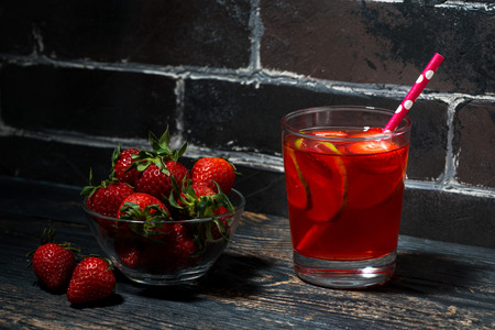 glass of strawberry lime lemonade on a dark wooden background, horizontalの写真素材