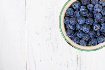 Fresh juicy blueberries in a bowl on whiteの写真素材