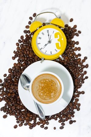 Espresso cup and alarm clock, conceptual photography, verticalの写真素材