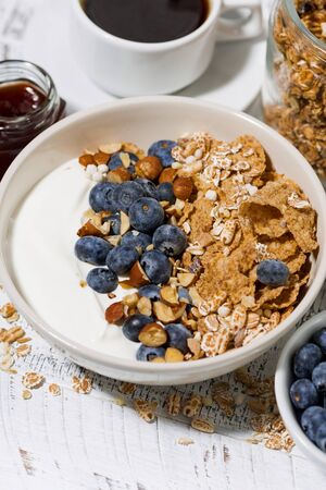 A bowl of healthy wholegrain flakes, yogurt and fresh blueberries for breakfast, closeupの写真素材