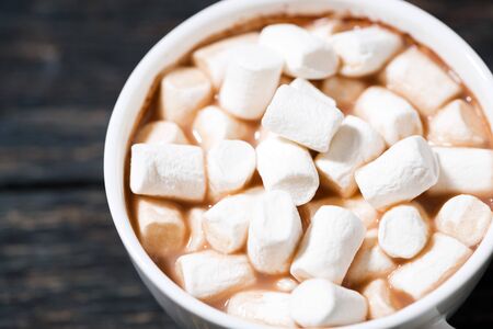 cup of cocoa with sweet marshmallows on a wooden table, closeup top viewの写真素材
