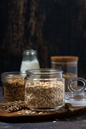 healthy foods - oatmeal, cereal and homemade granola on dark table, vertical closeupの写真素材
