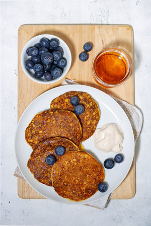 homemade pancakes with blueberries and yogurt on white background, top view