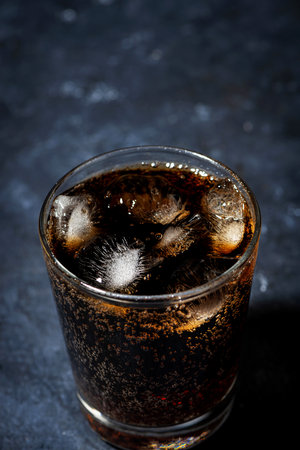 glass of cola with ice on a dark background, top view verticalの写真素材