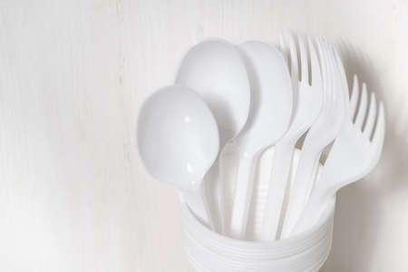 plastic disposable tableware - spoons and a glass on a white background, closeup horizontalの写真素材