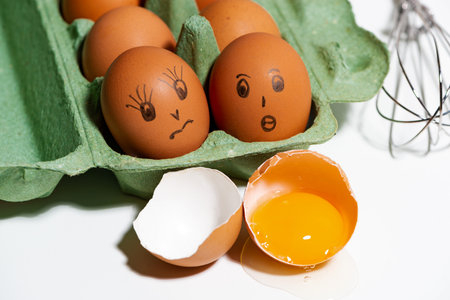 chicken eggs with painted faces, ingredients for baking, closeup top viewの写真素材