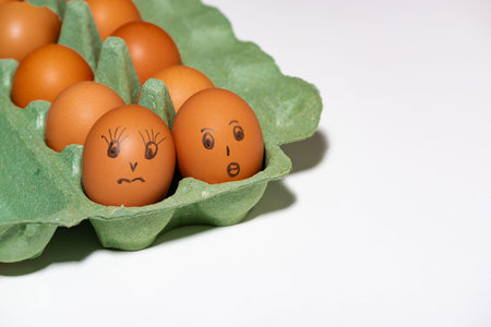 chicken eggs with painted faces on white background, horizontal