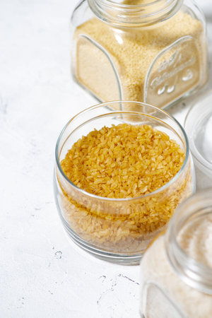 bulgur groats in a glass jar on a white background, vertical top viewの写真素材