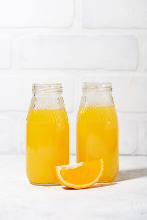 freshly squeezed orange juice in glass bottles, closeupの写真素材