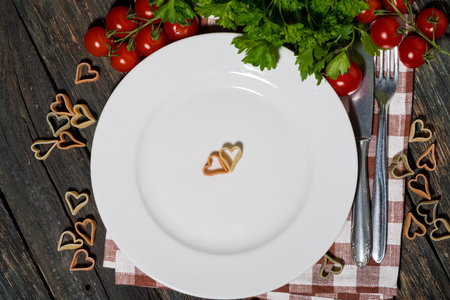 table setting with pasta and vegetables on wooden background, top viewの写真素材