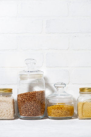 cereals in glass jars on a white background, vertical closeupの写真素材