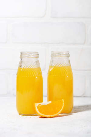 freshly squeezed orange juice in glass bottles, closeupの写真素材
