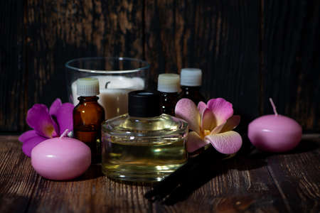 attributes of spa treatments - candles, aroma diffuser, rattan sticks and aroma oils on wooden background, closeupの写真素材