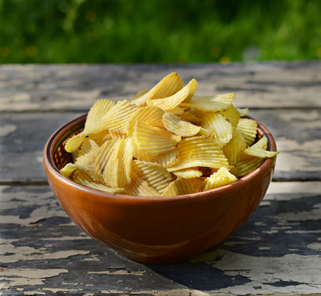 chips in a plate on old wooden table の写真素材