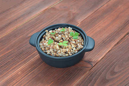 Buckwheat groats in a wooden brown tableの写真素材