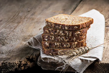 Sliced rye bread with sunflower seeds in wooden background. Space for textの写真素材