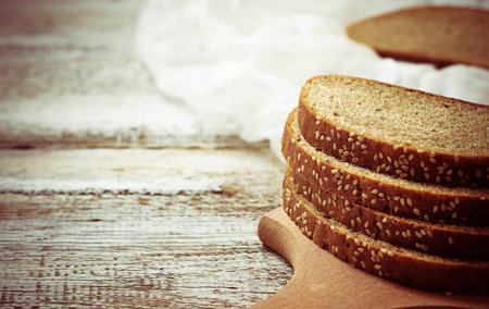 Sliced rye bread with sesame seeds. Selective focus. Toned photo. Space for text