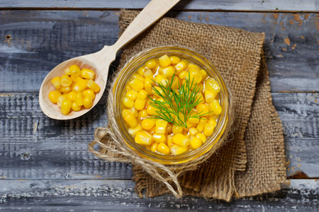 Canned sweet corn in wooden background. Selective focus