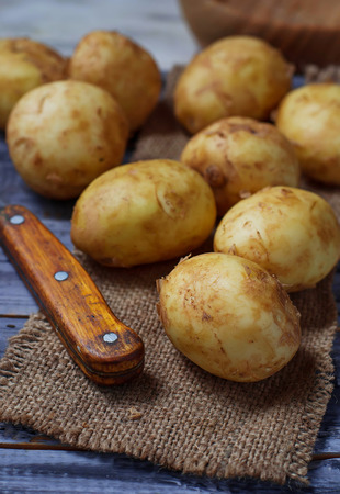 Fresh organic potatoes in wooden tableの写真素材