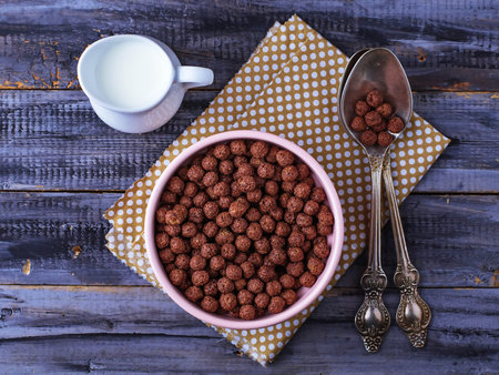 Chocolate cereal balls in bowl and milk. Selective focus