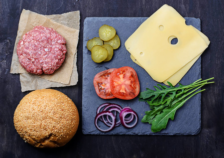 Ingredients for burger: raw cutlet, tomato, cheese, onion. Selective focusの写真素材
