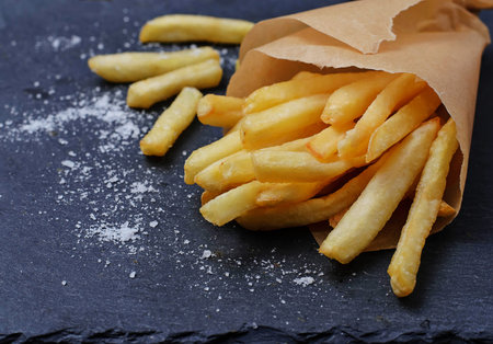 French fries in paper wrapper. Selective focus