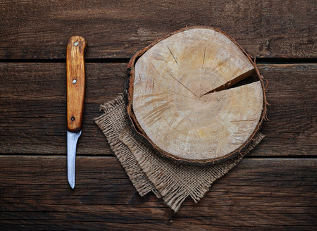 Wooden cutting board and knife on brown background.の写真素材
