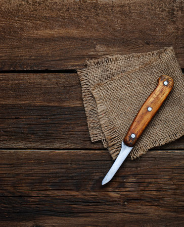 Knife and sucking napkin on wooden background. Selective focus