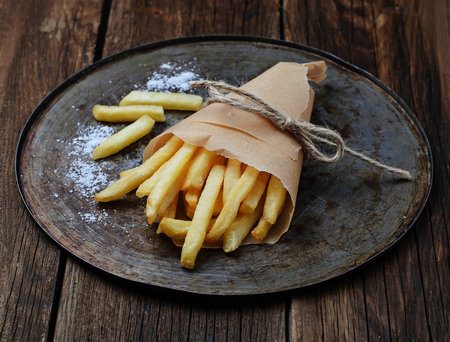 French fries in paper wrapper. Selective focus
