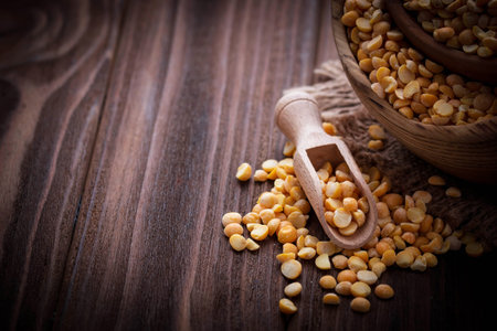 Yellow dry peas in wooden bowl. Selective focus