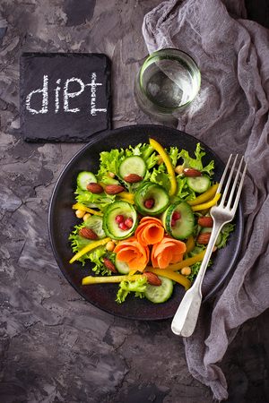 Vegetable salad with carrot, cucumber, pepper, almond and chick-pea. 
Concept of healthy food. Top viewの写真素材