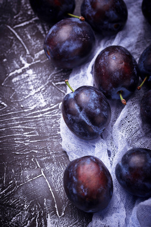 Fresh plums on concrete background. Selective focusの写真素材