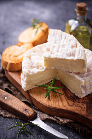 Camembert cheese with rosemary on wooden boardの写真素材