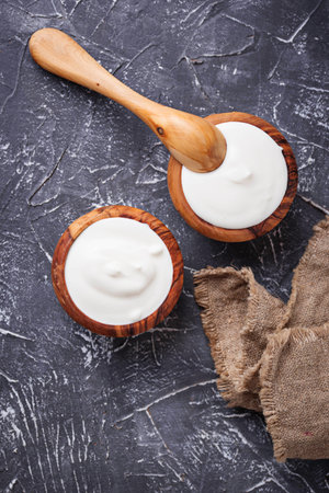 White Greek yogurt in wooden bowl. Top viewの写真素材