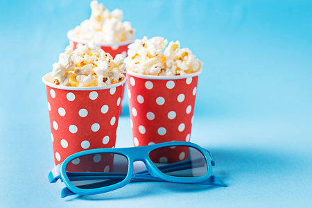 Popcorn with 3d glasses on blue backgroundの写真素材