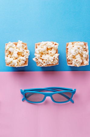 Popcorn with 3d glasses on blue backgroundの写真素材