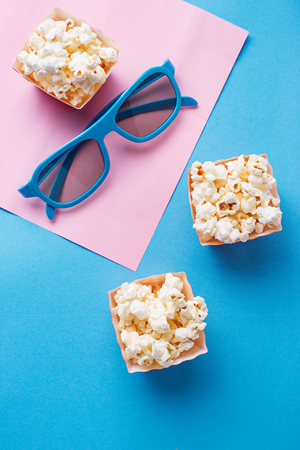 Popcorn with 3d glasses on blue backgroundの写真素材