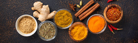 Traditional Indian spices. Turmeric, chili pepper, curry, ginger, dry herbs and saffron. Banner for...
