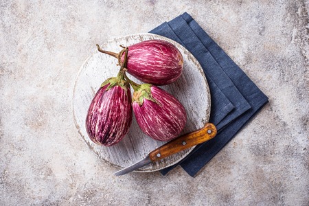 Fresh striped purple aubergines on light backgroundの写真素材