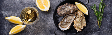 Fresh oysters with lemon and white wine. Top view, banner for site designの写真素材