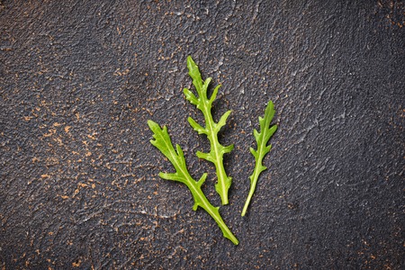 Fresh arugula leaves on rusty tableの写真素材