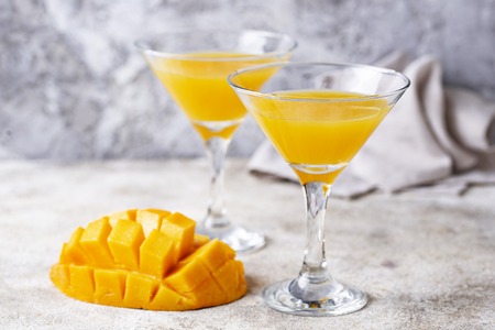 Tropical cocktail with mango on light backgroundの写真素材