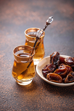 Traditional arabic tea and dry dates. Selective focusの写真素材