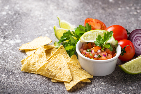 Traditional mexican tomato salsa sauce and corn chips nachosの写真素材