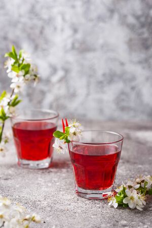 Glasses of healthy cherry juice on grey backgroundの写真素材