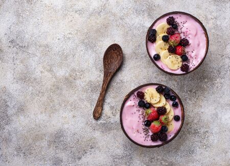Acai bowl in coconut plate. Trendy healthy foodの写真素材